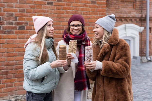 medium shot women holding chimney cakes