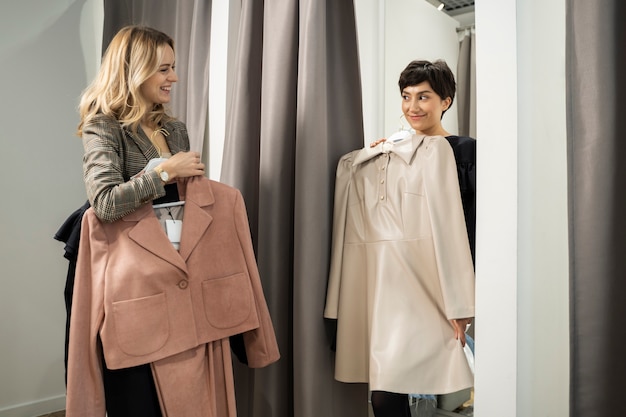 Medium shot women holding clothes