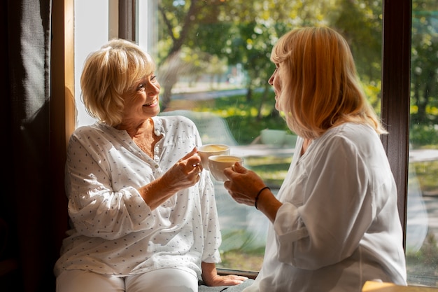 Medium shot women holding coffee cups