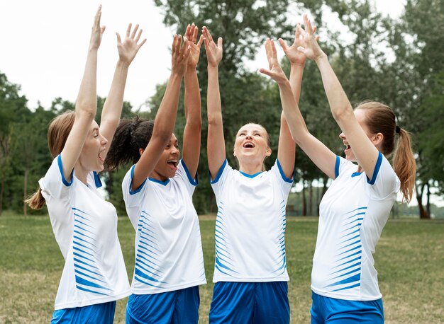 Medium shot women holding hands up