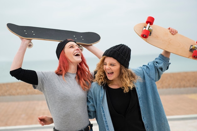 Medium shot women holding skateboards