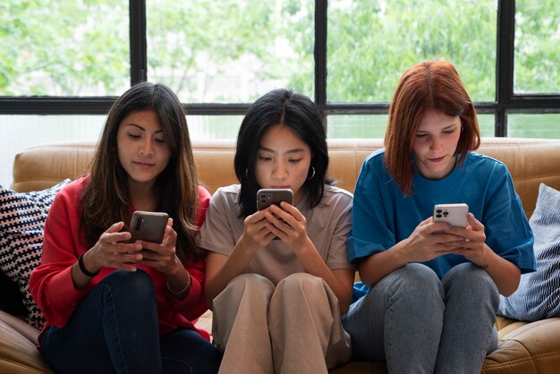 Medium shot women holding smartphones