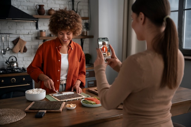 Free photo medium shot women learning to make sushi