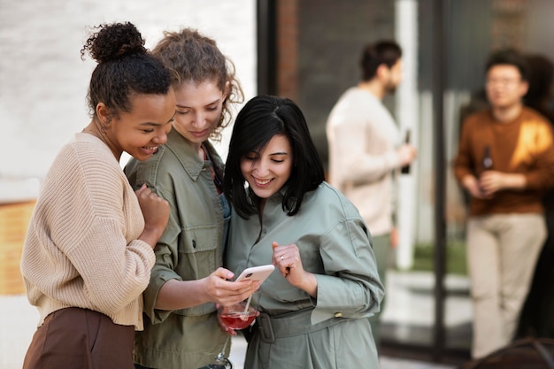 Medium shot women looking at phone