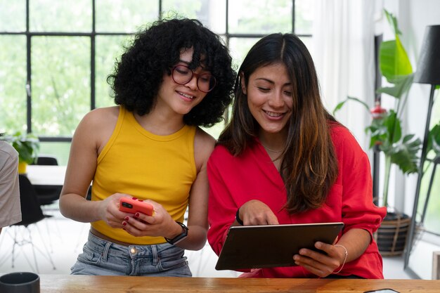 Medium shot women looking at tablet