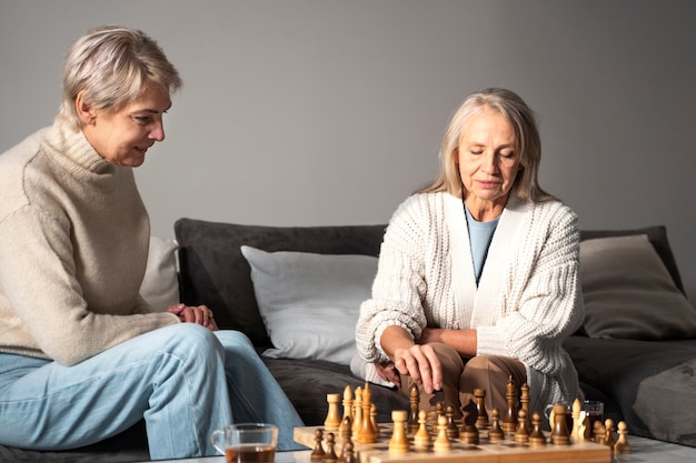 Medium shot women playing chess