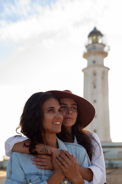 Medium shot women posing with lighthouse