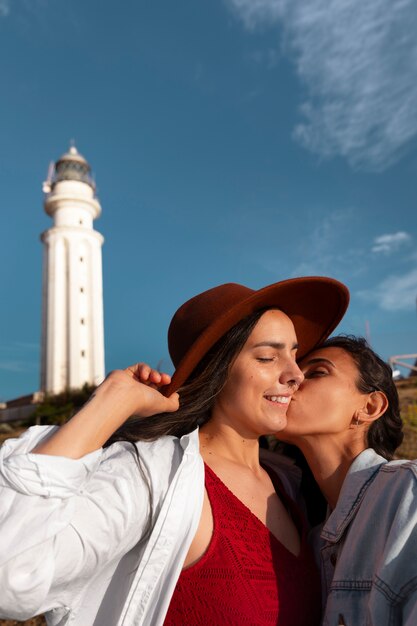 Женщины со средним снимком позируют с маяком