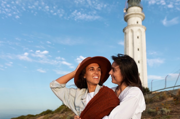 灯台とポーズをとっている中型の女性