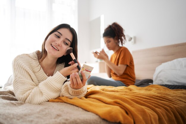 Medium shot women putting on makeup