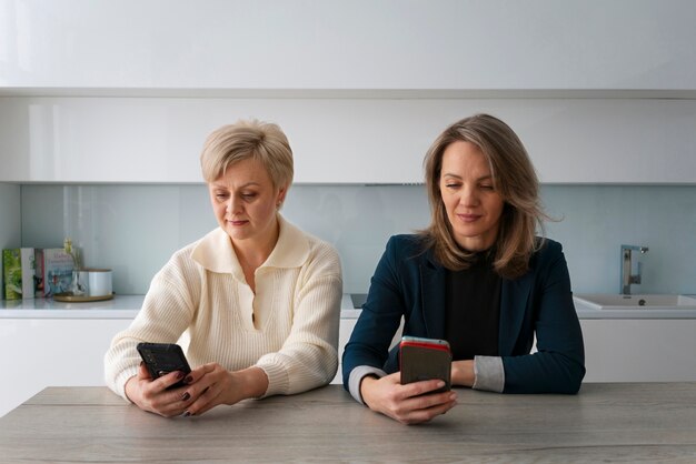 Женщины среднего роста читают сообщения мобильного телефона