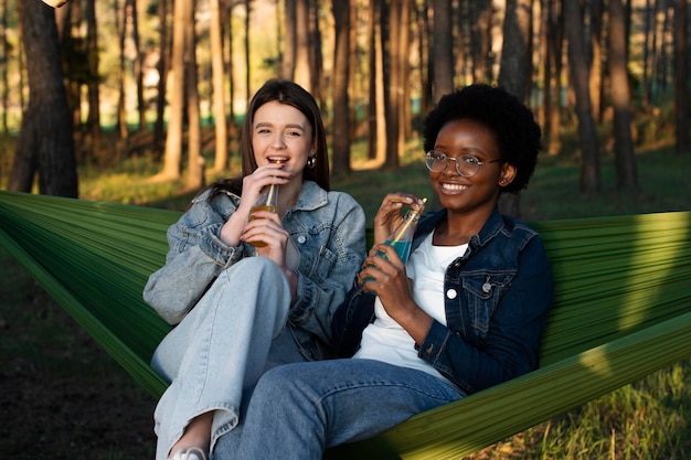 Free photo medium shot women sitting in hammocks