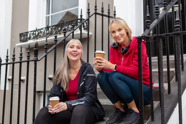 Medium shot women sitting together on stairs