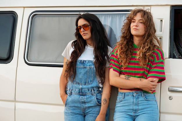 Medium shot women standing near campervan