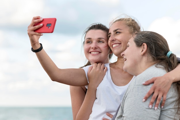 Medium shot women taking selfie