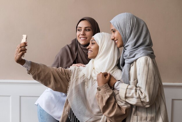 Medium shot women taking selfie