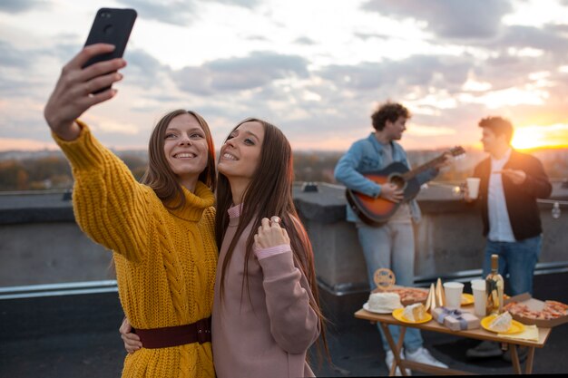 Medium shot women taking selfie