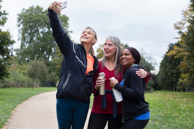 Free photo medium shot women taking selfie