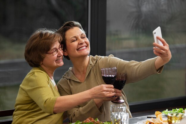 Medium shot women taking selfie