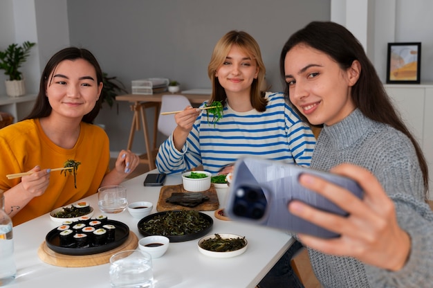 Free photo medium shot women taking selfie