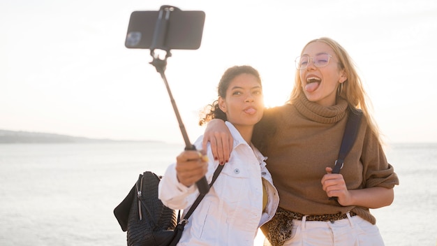 Medium shot women taking selfies