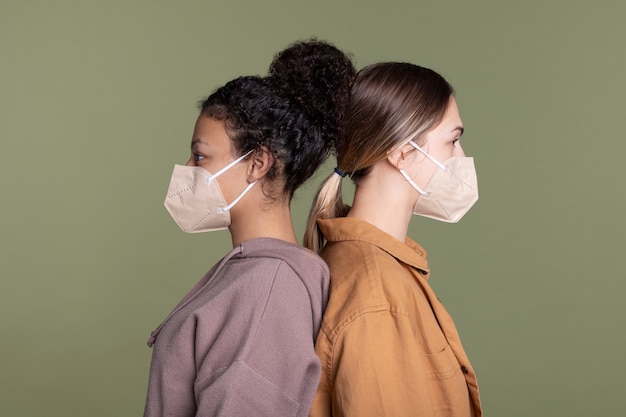 Foto gratuita donne di tiro medio che indossano maschere per il viso