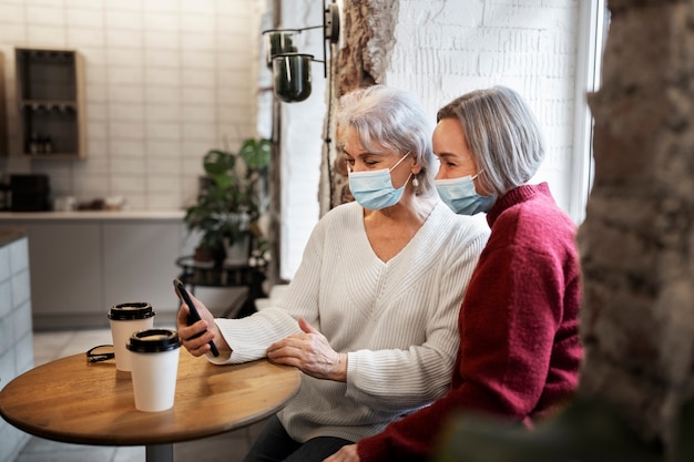 Free photo medium shot women wearing face masks