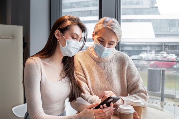 Free photo medium shot women wearing masks