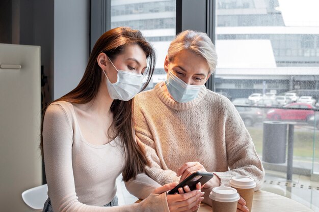 Medium shot women wearing masks