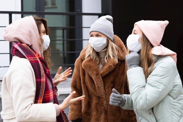 Medium shot women wearing protective masks