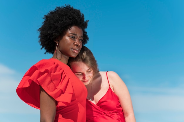 Free photo medium shot women wearing red dresses