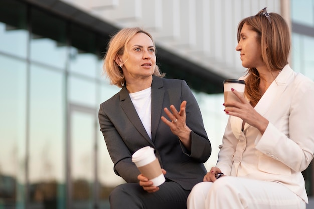 Medium shot women with coffee cups outdoors