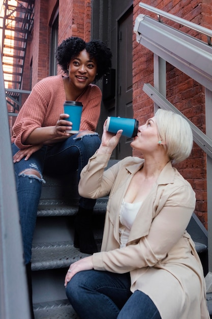 Free photo medium shot women with coffee cups