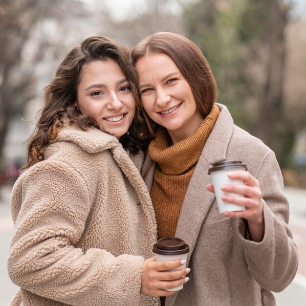 Medium shot women with coffee outdoors