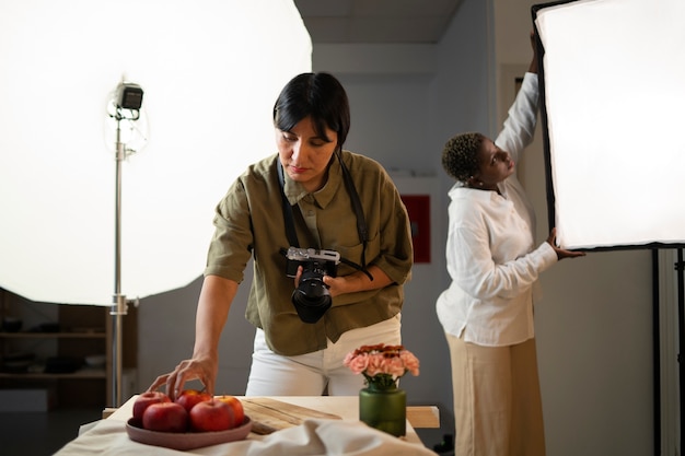 Foto gratuita donne del piano medio che lavorano come fotografo