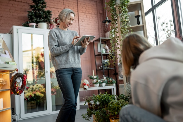 Бесплатное фото Среднего плана женщины, работающие в цветочном магазине