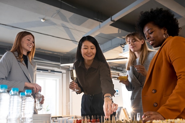 Free photo medium shot workers chatting at company event