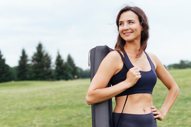 Medium shot yoga woman posing outdoors