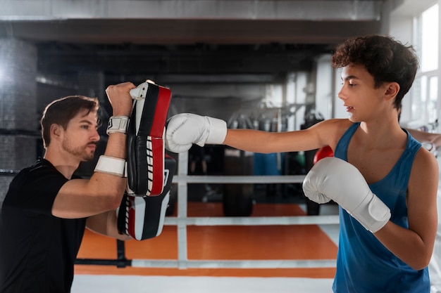 Free photo medium shot young boy boxing