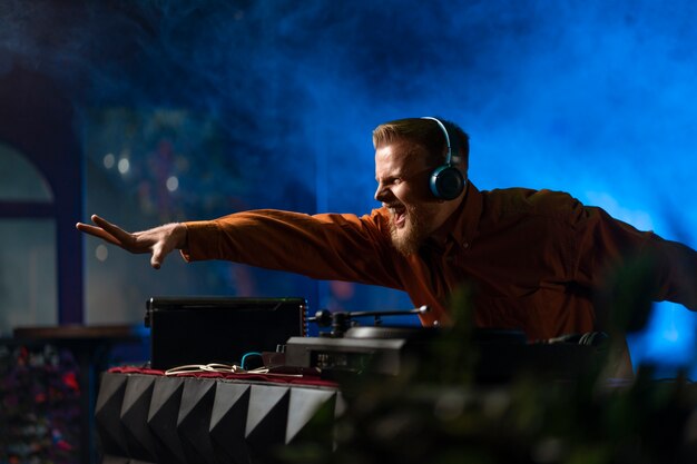 medium shot young dj at techno party