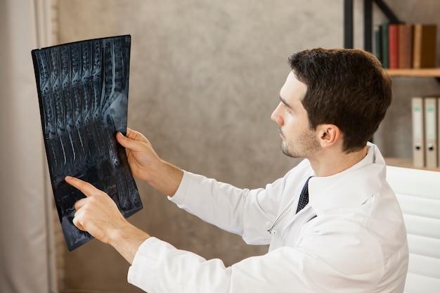 Free photo medium shot young doctor checking radiography