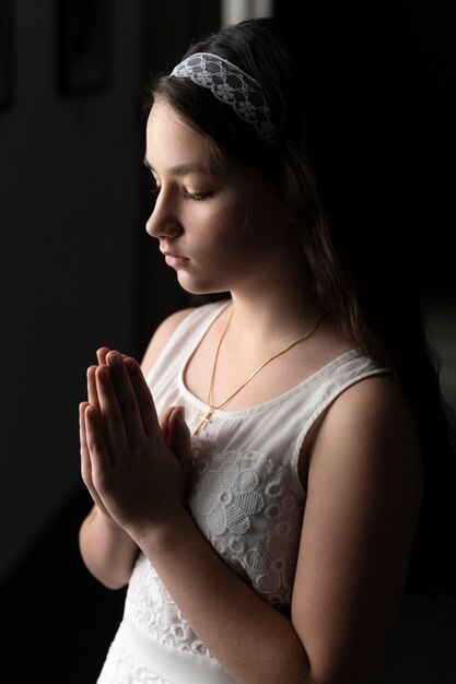 Medium shot young girl praying