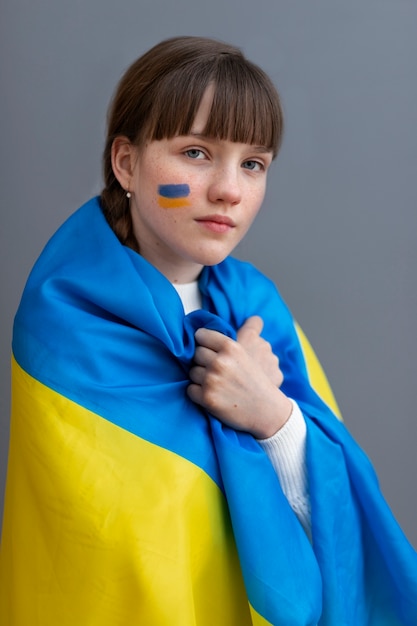 Medium shot young girl wearing ukrainian flag