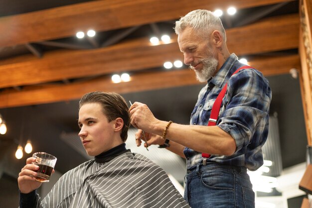 Medium shot young man getting haircut