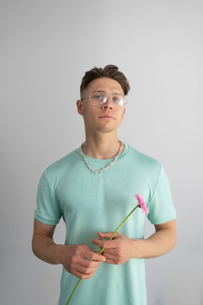 Free photo medium shot young man holding flower