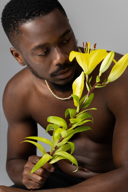 Medium shot young man posing with flower