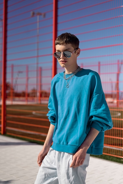 Medium shot young man posing with sunglasses