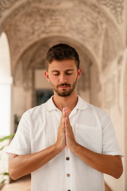 Foto gratuita tiro medio giovane uomo che prega