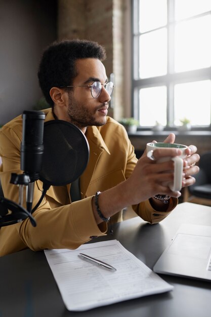 Medium shot young man recording podcast