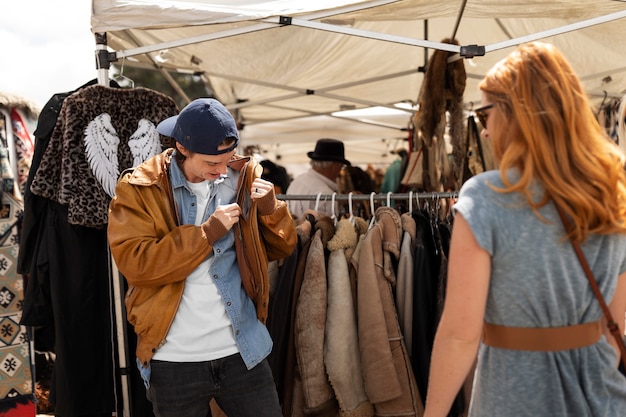 Free photo medium shot young man trying on jacket